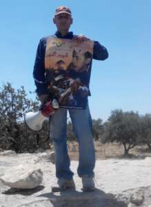 Palestyńczyk z plakatem upamiętniającym śmierć Muhammada Abu Chidajra