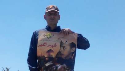 Palestyńczyk z plakatem upamiętniającym śmierć Muhammada Abu Chidajra