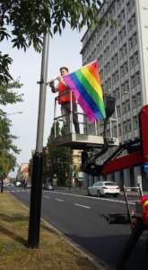 Aktywista Grupy Stonewall zawiesza tęczową flagę / fot. Grupa Stonewall